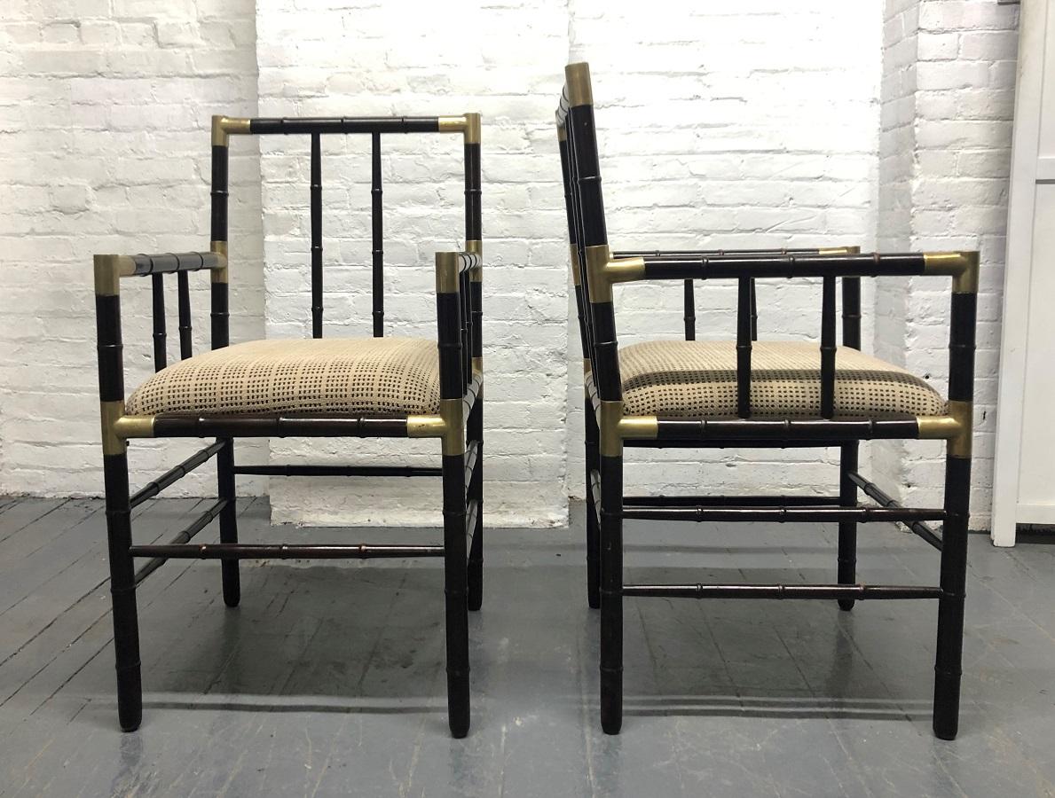 Billy Haines style faux bamboo armchairs. The chairs are wood with a faux bamboo pattern with bronze mounts. 

 
