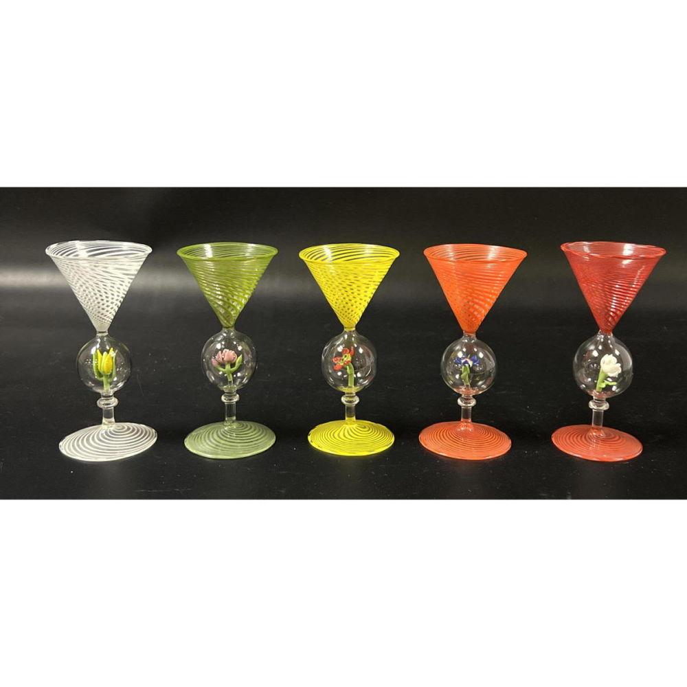 Bimini Werkstatte Venetian Cordial Glasses with Flower Decoration,
Set of Five,
Austria,
1930s

The five Bimini Venetian swirl colored glasses each have a different color swirl.  On the stem is a glass bubble containing lampwork in the form of