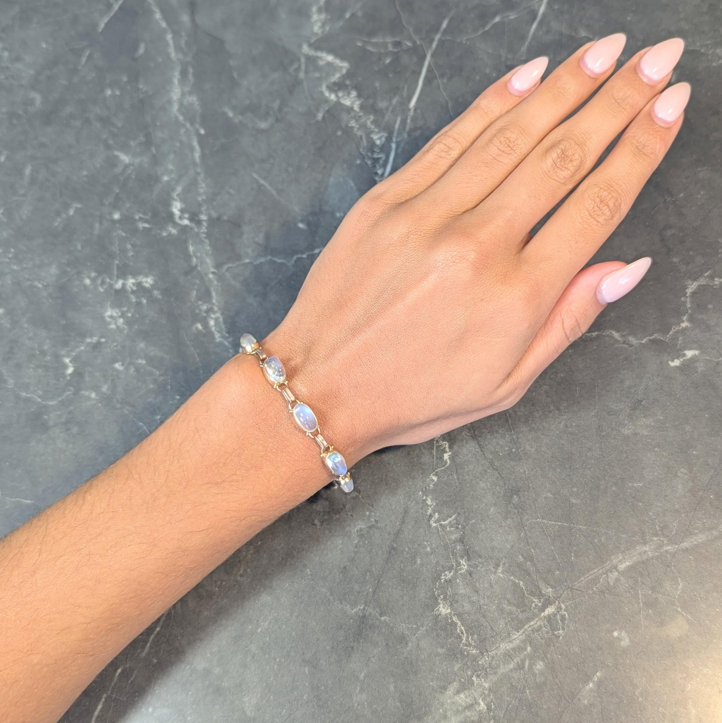 Comprised of rose gold oval bar links alternating with yellow gold bezel links
Set with oval sugarloaf moonstone cabochons measuring 9.5 x 5.5 mm 
Translucent colorless body with vivid blue adularescence 
Bezel links are decorated with gold