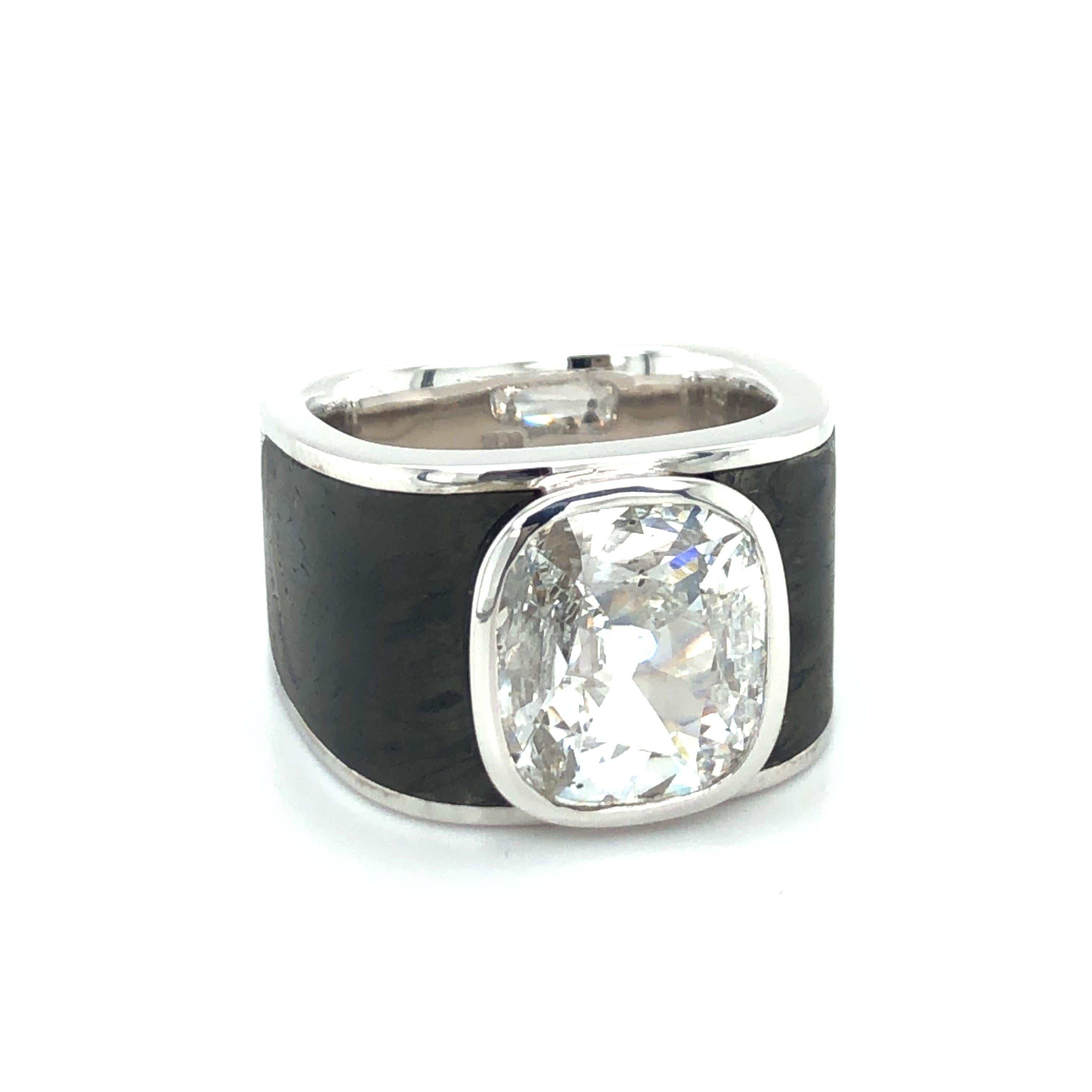 This superb handcrafted ring by renowned Swiss jeweller BINDER MOERISCH features a stunning, 3.41 carat cushion shaped diamond of D colour and si2 clarity.
Bezel set in a bold mounting made of 18 karat white gold and finely structured black carbon,