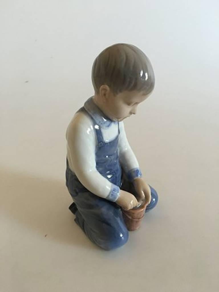 Bing & Grondahl figurine #2127 of boy with bucket. Measures: 13.5 cm tall (5 5/16 inches).