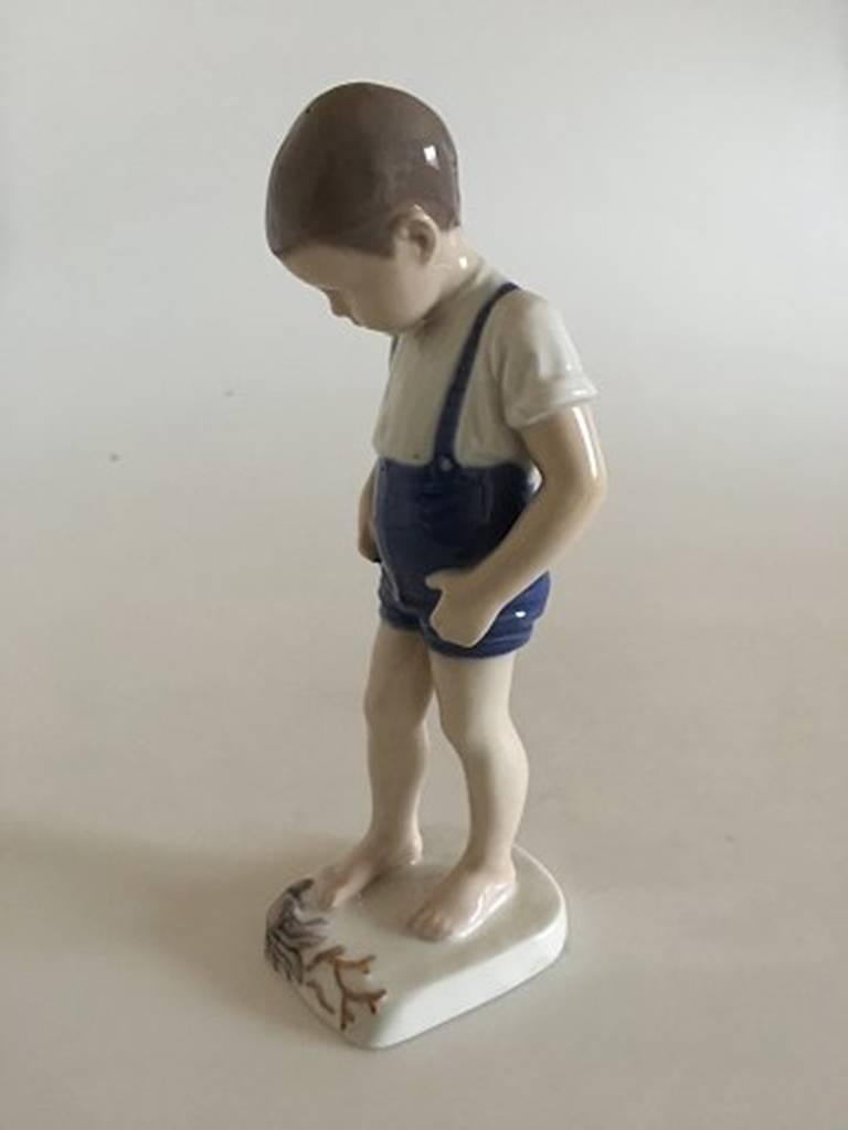 Bing & Grondahl figurine boy with crab #1870. Measures 20cm and is in good condition.