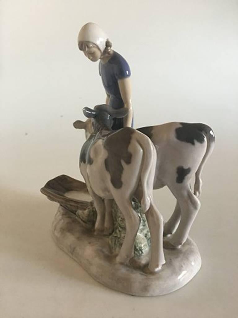 Bing & Grondahl figurine girl with calves #2270. Measures 21cm and is in good condition. Designed by Axel Locher.