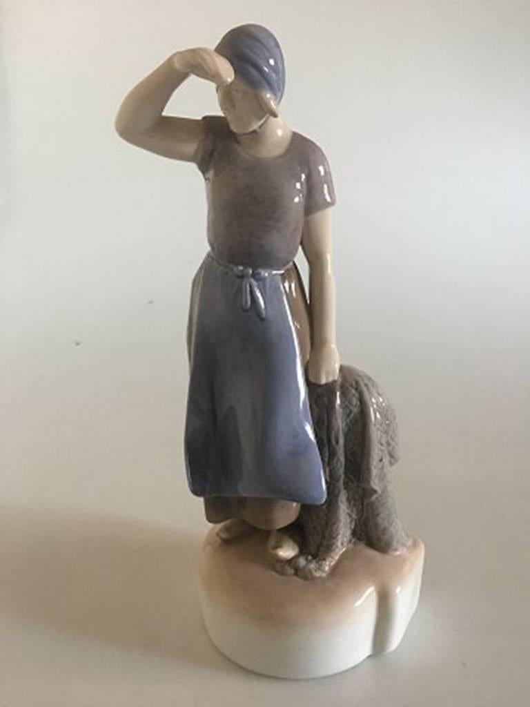 Bing & Grondahl figurine girl with fishnet #2036. Designed by Axel Locher and measures 22.5cm.