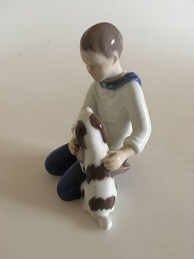 Bing & Grondahl figurine of boy brushing his dog #2334. 1st quality. Measures: 12 cm H (4 23/32 in).