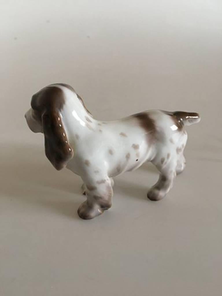 Bing & Grondahl figurine of Spaniel #2172. Measures: 8 x 10.5 cm. Has a chip on the one paw.