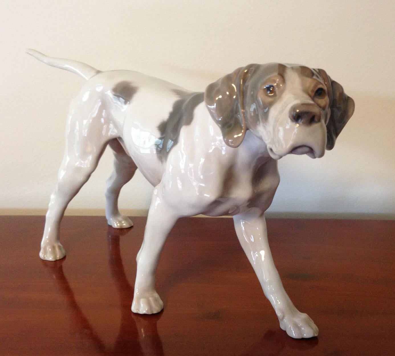 A rare Danish Bing & Grondahl brown and white figurine of a pointer dog, designed by Lauritz Jensen.

Marked and signed on bottom of the left hind leg B&G 2006 R - Model number 2006.

Marked on bottom of the right hind leg 3 towers B&G