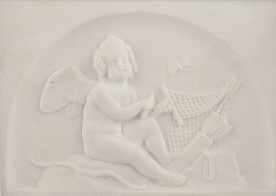 Bing & Grøndahl. Amor makes a net. Biscuit relief after Bertel Thorvaldsen.
Approximately from 1880. 
Copy of relief modelled in Rome in 1831.
Marked.
First factory quality.
In excellent condition with microscopic chips on the edge.
Dimensions: W