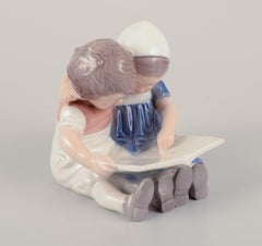 Bing & Grøndahl, Denmark. Porcelain figurine of reading children.
