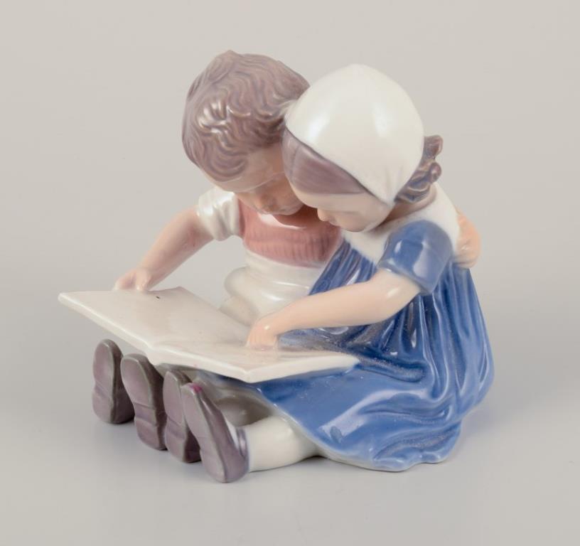 Danese Bing & Grøndahl, Danimarca. Statuetta in porcellana di bambini che leggono. in vendita