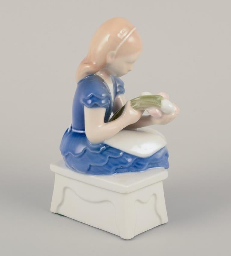 Danese Bing & Grøndahl, Danimarca. Statuetta in porcellana di ragazza seduta con fiori. in vendita