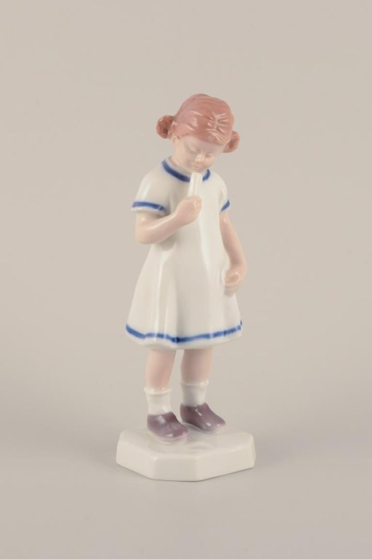 Bing & Grøndahl, Dänemark. Seltene Porzellanfigur. 
Junges Mädchen mit Eiscreme.
Mitte des 20. Jahrhunderts.
Markiert.
Erste Fabrikqualität.
In perfektem Zustand.
Abmessungen: Höhe 18,5 cm. x Durchmesser 6,2 cm.