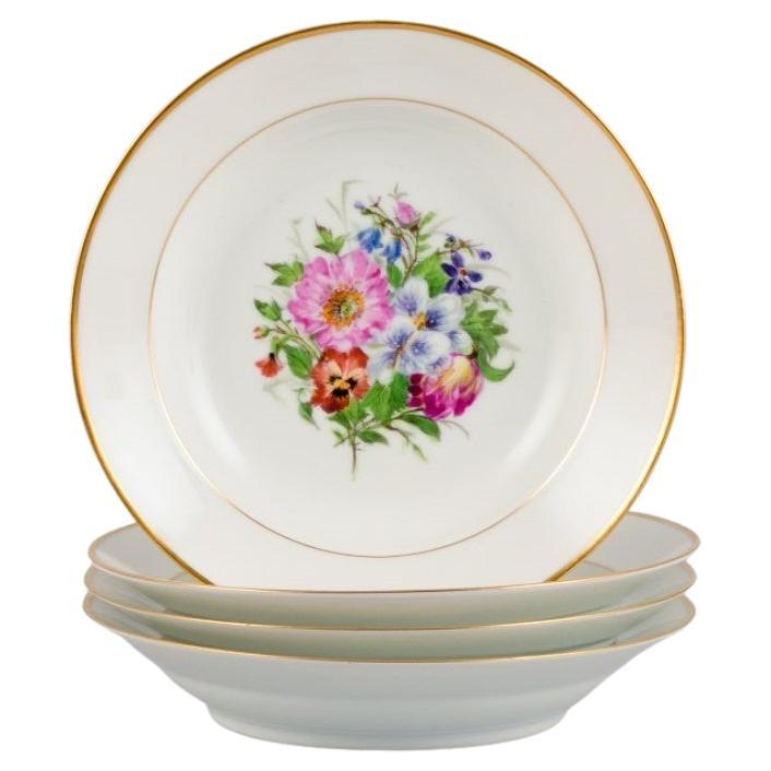 Bing & Grøndahl, four deep plates in porcelain with flowers and gold decoration