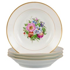Antique Bing & Grøndahl, four deep plates in porcelain with flowers and gold decoration