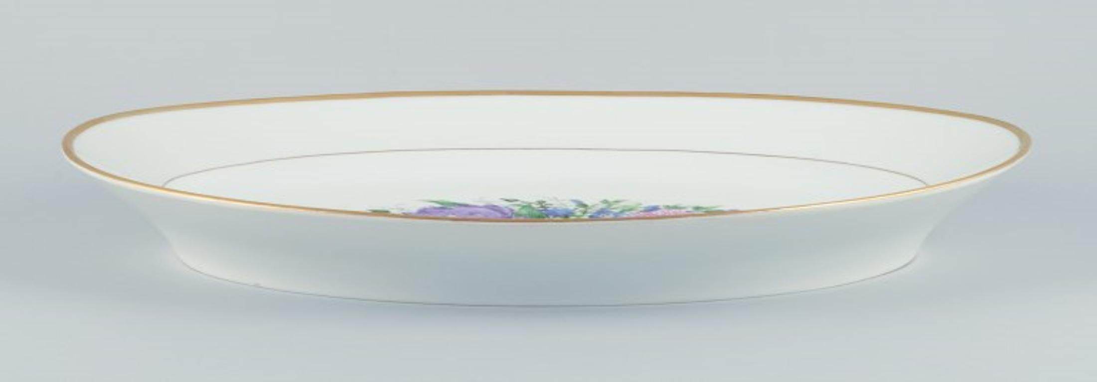Bing & Grøndahl, large oval serving platter hand-painted with polychrome flower motifs and gold trim.
From the 1920s.
Marked.
First factory quality.
Perfect condition.
Dimensions: Length 46.5 cm x Depth 32.5 cm x Height 5.0 cm.