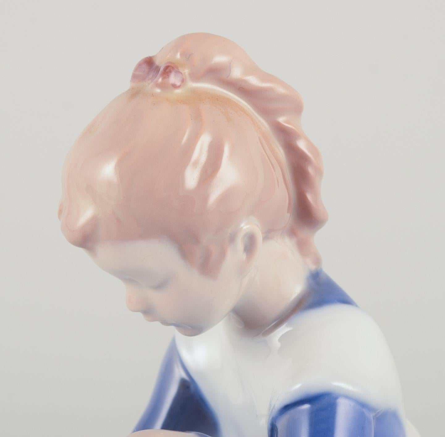 Danish Bing & Grøndahl porcelain figurine. Sitting girl tying a shoelace. For Sale