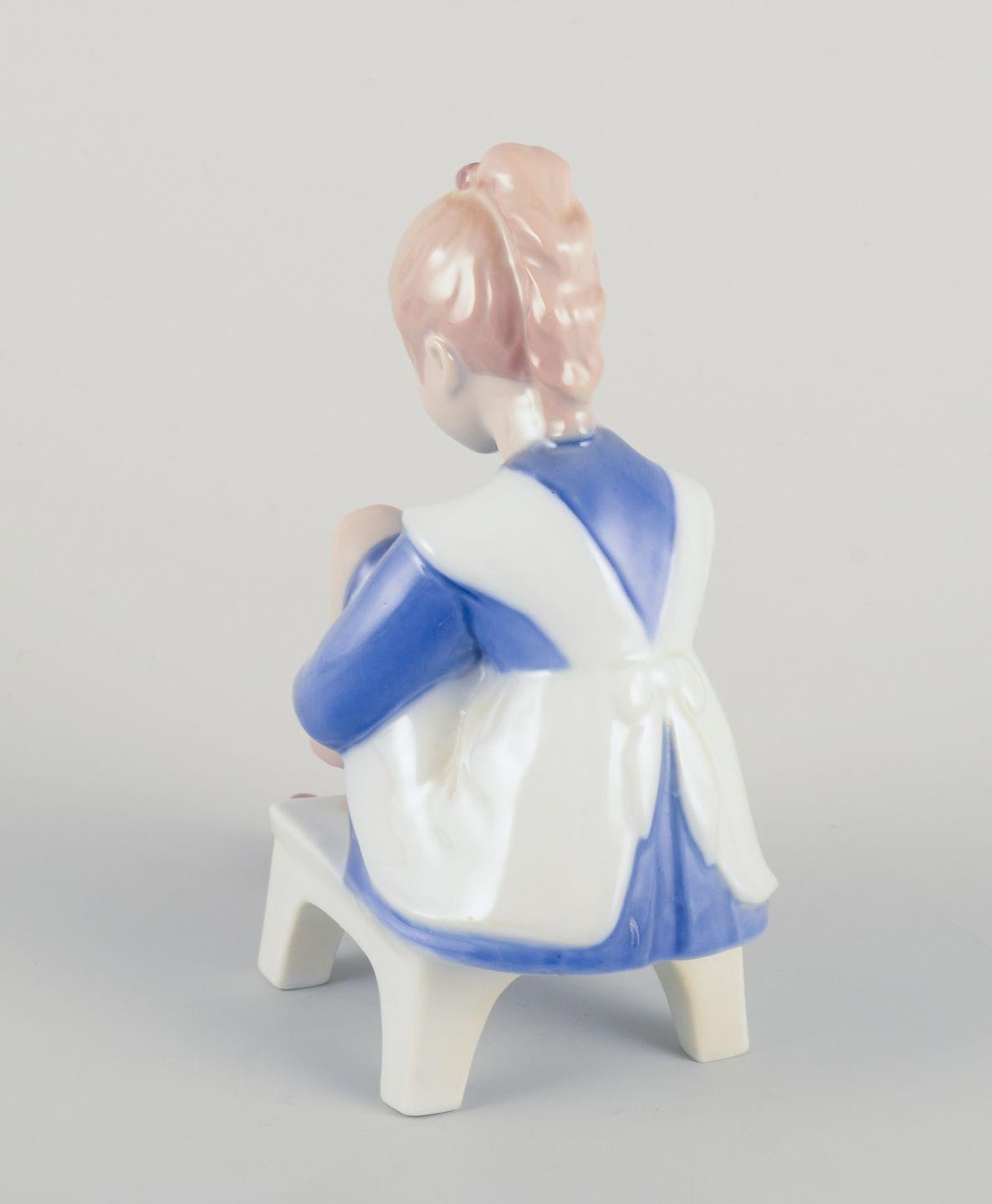 Hand-Painted Bing & Grøndahl porcelain figurine. Sitting girl tying a shoelace. For Sale