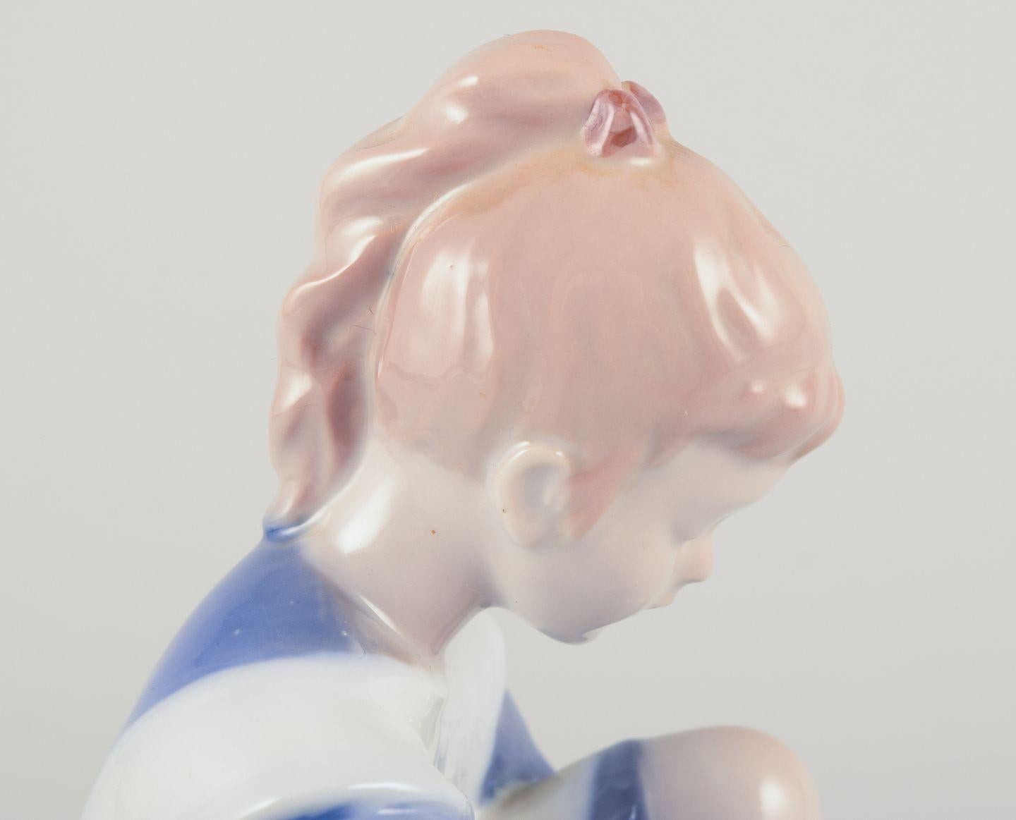 Bing & Grøndahl porcelain figurine. Sitting girl tying a shoelace. In Good Condition For Sale In Copenhagen, DK