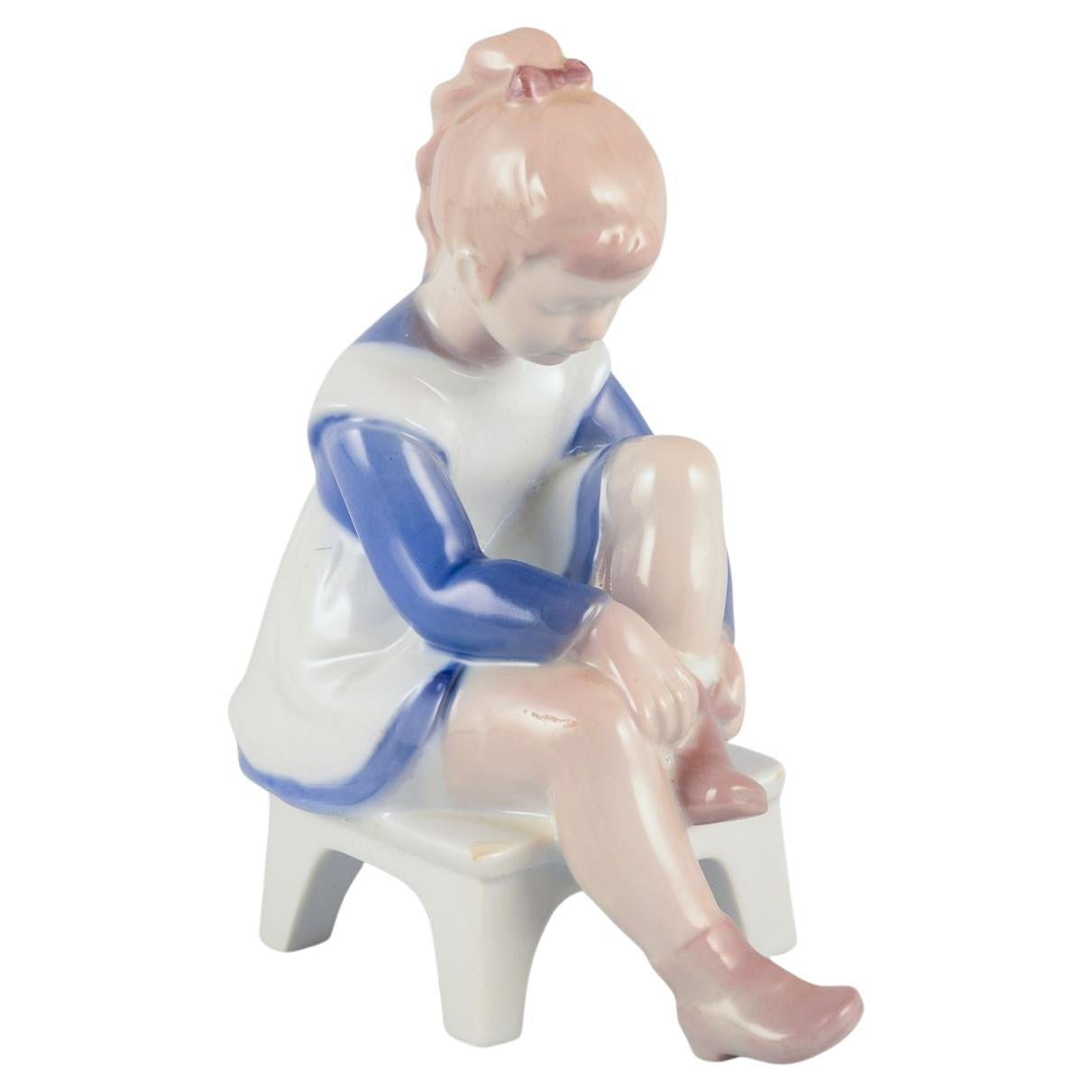 Bing & Grøndahl porcelain figurine. Sitting girl tying a shoelace. For Sale