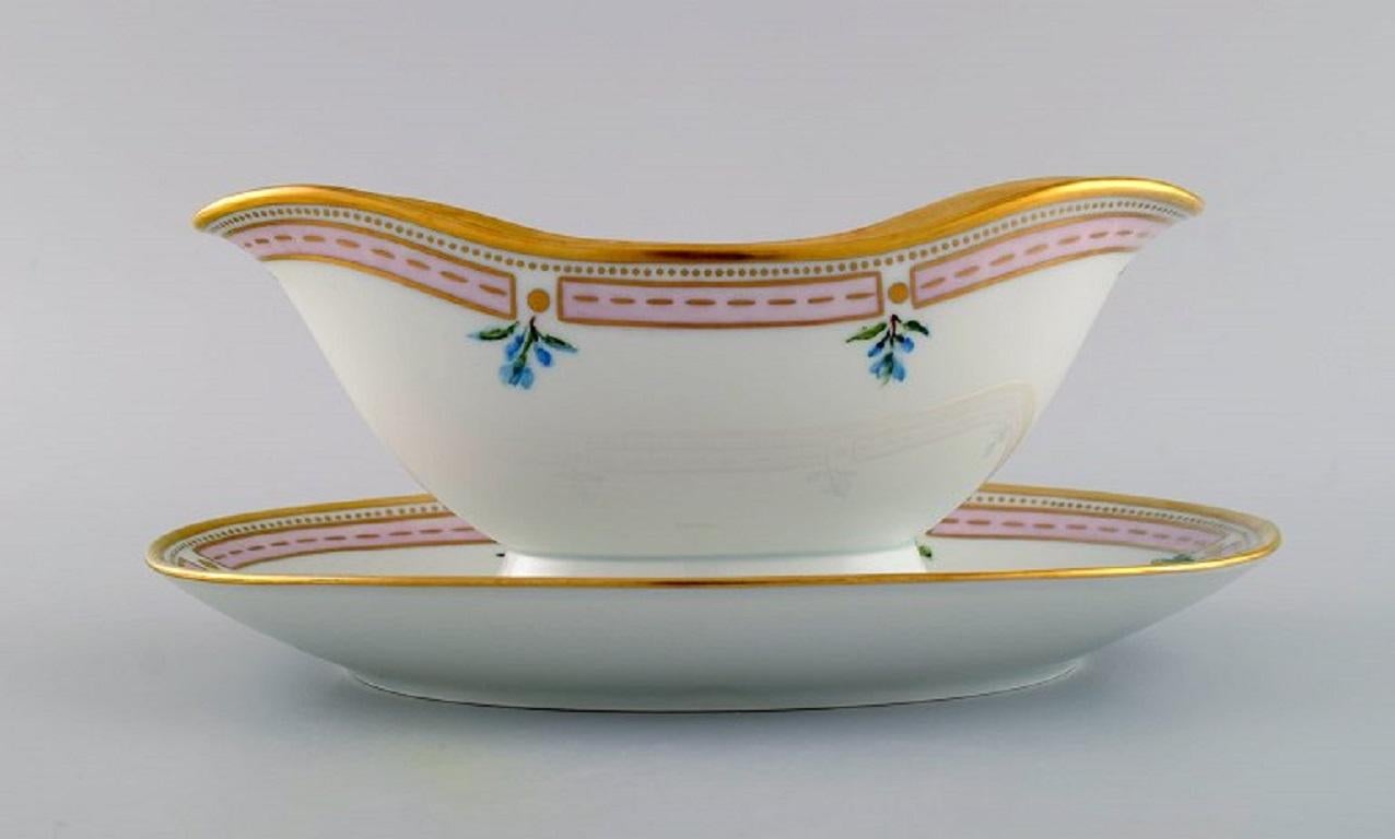 Bing & Grøndahl porcelain sauce boat with hand-painted flowers and gold decoration. 
Flora Danica style, 1920s / 30s.
Measures: 24 x 10 cm.
In excellent condition.
Stamped.
2nd factory quality.