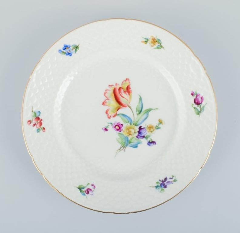 Bing & Grøndahl, Saxon Flower, a lunch plate, two oval bowls, and a salt and pepper set. 
Hand-decorated with polychrome flowers and gold rim.
Approximately from the 1930s.
Model numbers: 26 + 39.
Marked.
First factory quality.
In excellent
