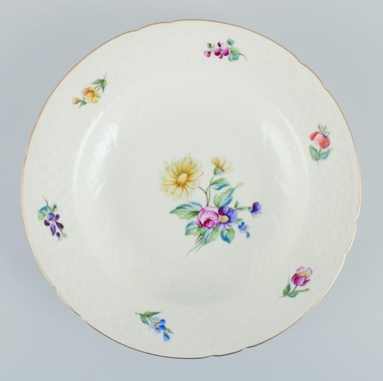 Bing & Grøndahl, Saxon Flower, un ensemble de quatre assiettes creuses décorées à la main de fleurs polychromes et d'un bord doré.
Datant approximativement des années 1930.
Numéro de modèle 22.
Marqué.
Première qualité d'usine.
En parfait