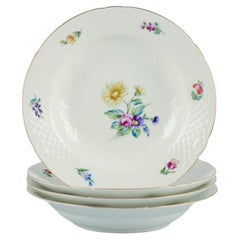Bing & Grøndahl, Saxon Flower, ensemble de quatre assiettes creuses en porcelaine, vers les années 1930.