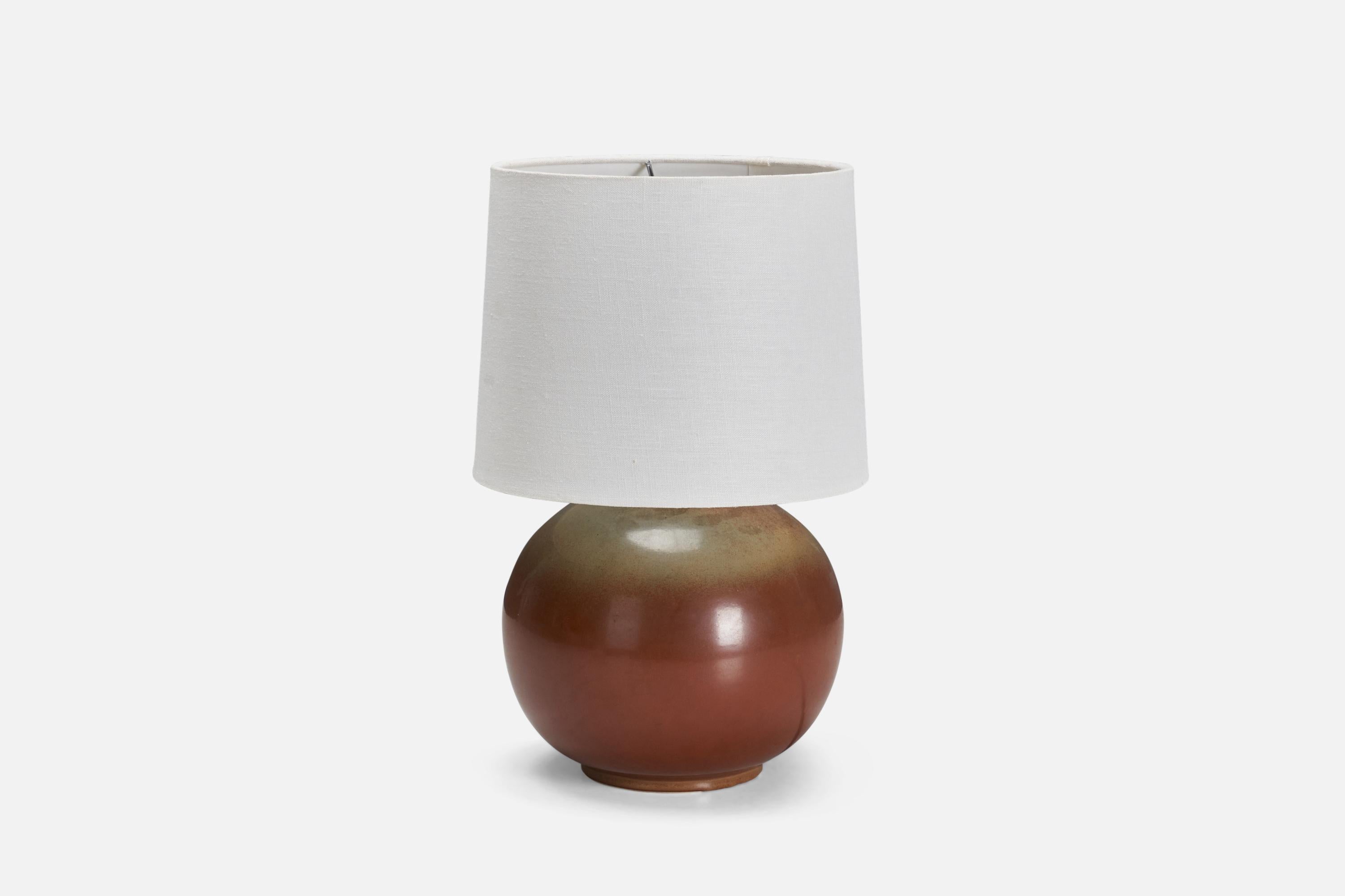 A sizable table lamp, model Nylund. Produced by Bing & Grøndahl, Denmark, 1940s. Features a vintage lampshade, possibly the original lampshade.

Glaze features orange-green colors.

