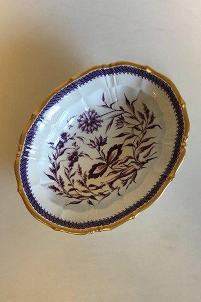 Bing & Grondahl Art Nouveau oval bowl on foot. Decorated with purple flowers. 

Measures 28 cm / 11 1/32 in. x 23 cm / 9 1/16 in. x 8 cm / 3 5/32 in. With hoveddepot mark.