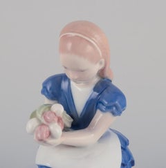 Bing & Grondahl, Denmark. Porcelain figurine of a seated girl with flowers