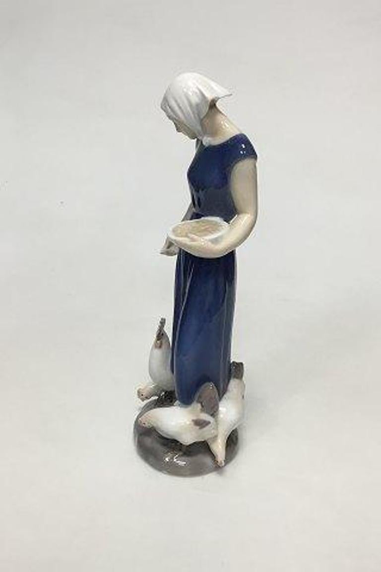 Bing & Figurine Grondahl d'une fille nourrissant des poulets No 2220. 

Mesure 22::5 cm / 8 55/64 in.