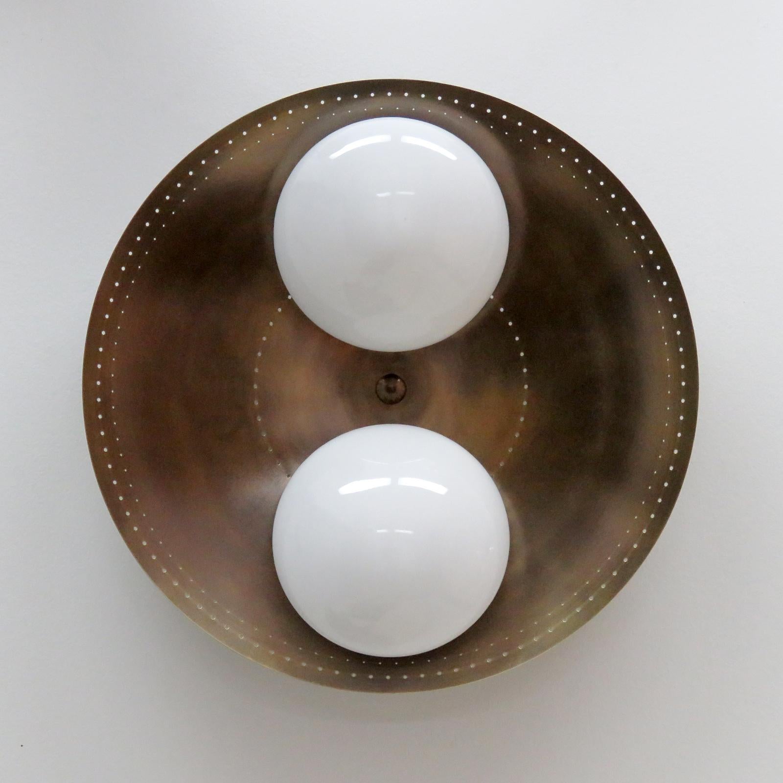 Elegant Binova-24 wall or ceiling light designed by Gallery L7, handcrafted and finished in Los Angeles from American brass, with two opaline glass shades on an aged raw brass disc. Two E26 sockets per fixture, max. wattage 60w each, wired for US