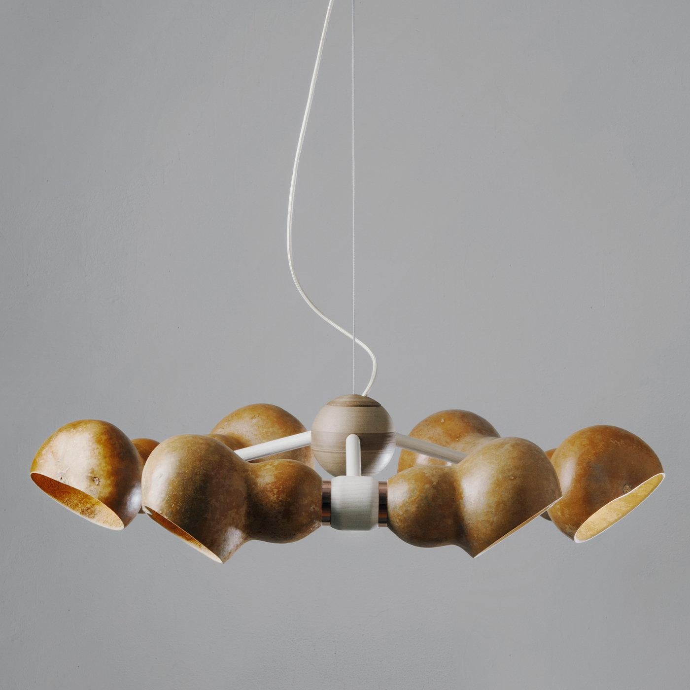 Bio Cloud is an elegant sustainable chandelier made of dried Lagenaria gourd that floats in the air like a cloud. From the 3D printed hemp heart of the lamp, three bows branch out creating a harmonious bond. This union gives a warm and singular