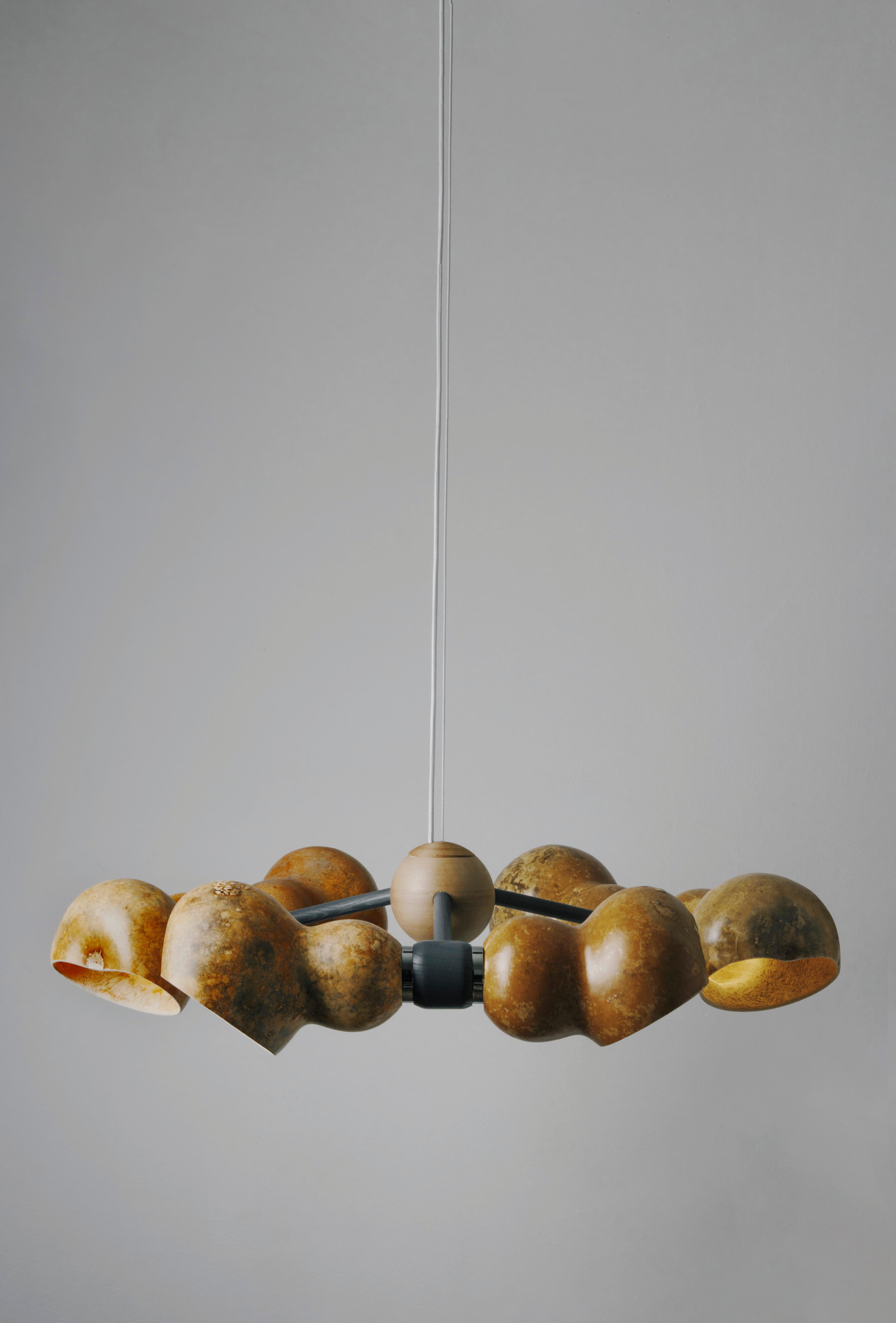 Bio Clous Grey chandelier by Margherita Sala
Dimensions: D90 x H20 cm
Materials: dried gourd, ash wood, chrome plated brass,
hemp sphere. Lampshade made of Lagenaria dried pumpkin.
Metal accessories: brass, copper or chrome.
Also available in