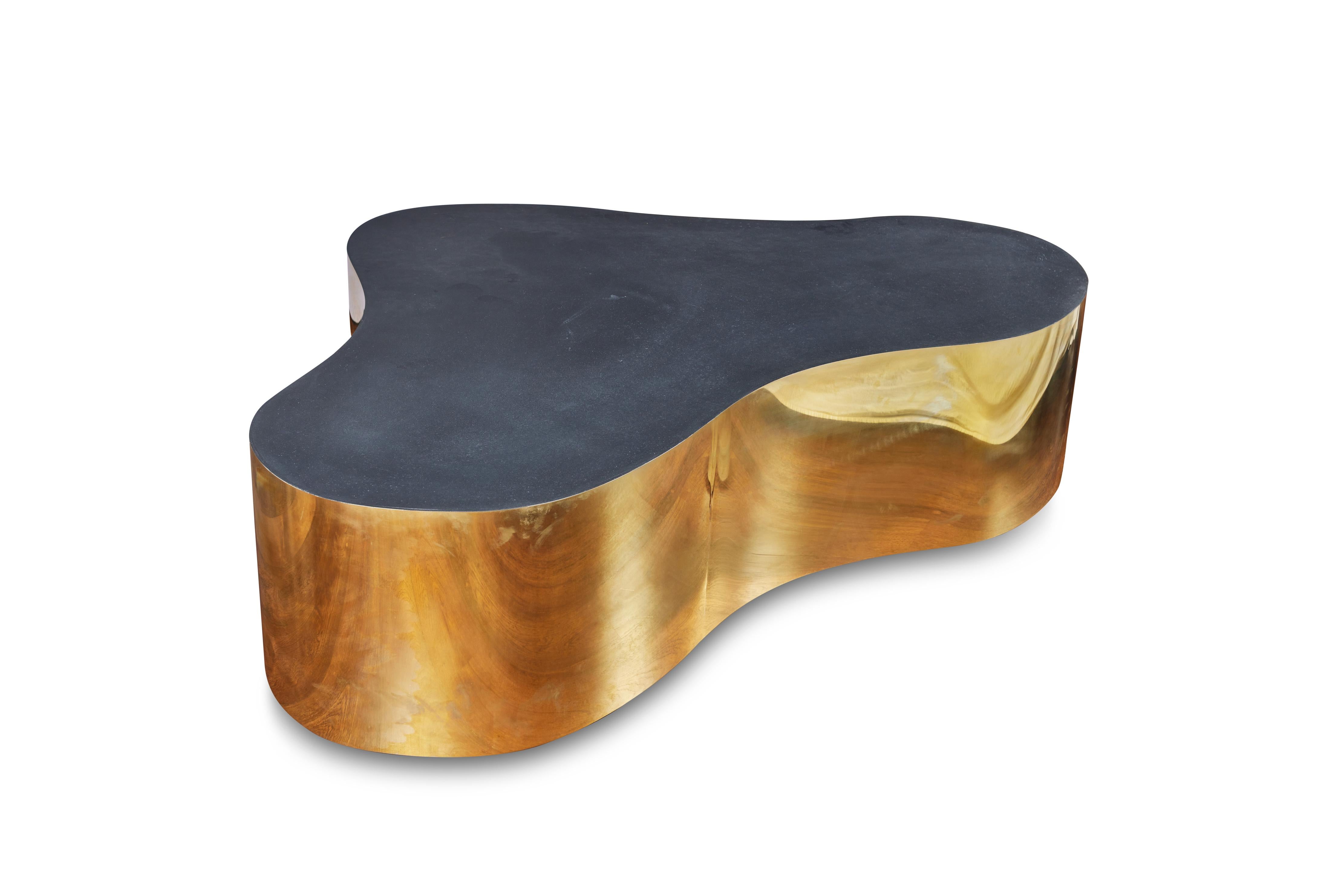 Spectacular, sculptural, biomorphic shape coffee table in the style of Karl Springer. the free form base is wrapped in sheet brass and the top is finished in a black laminate.