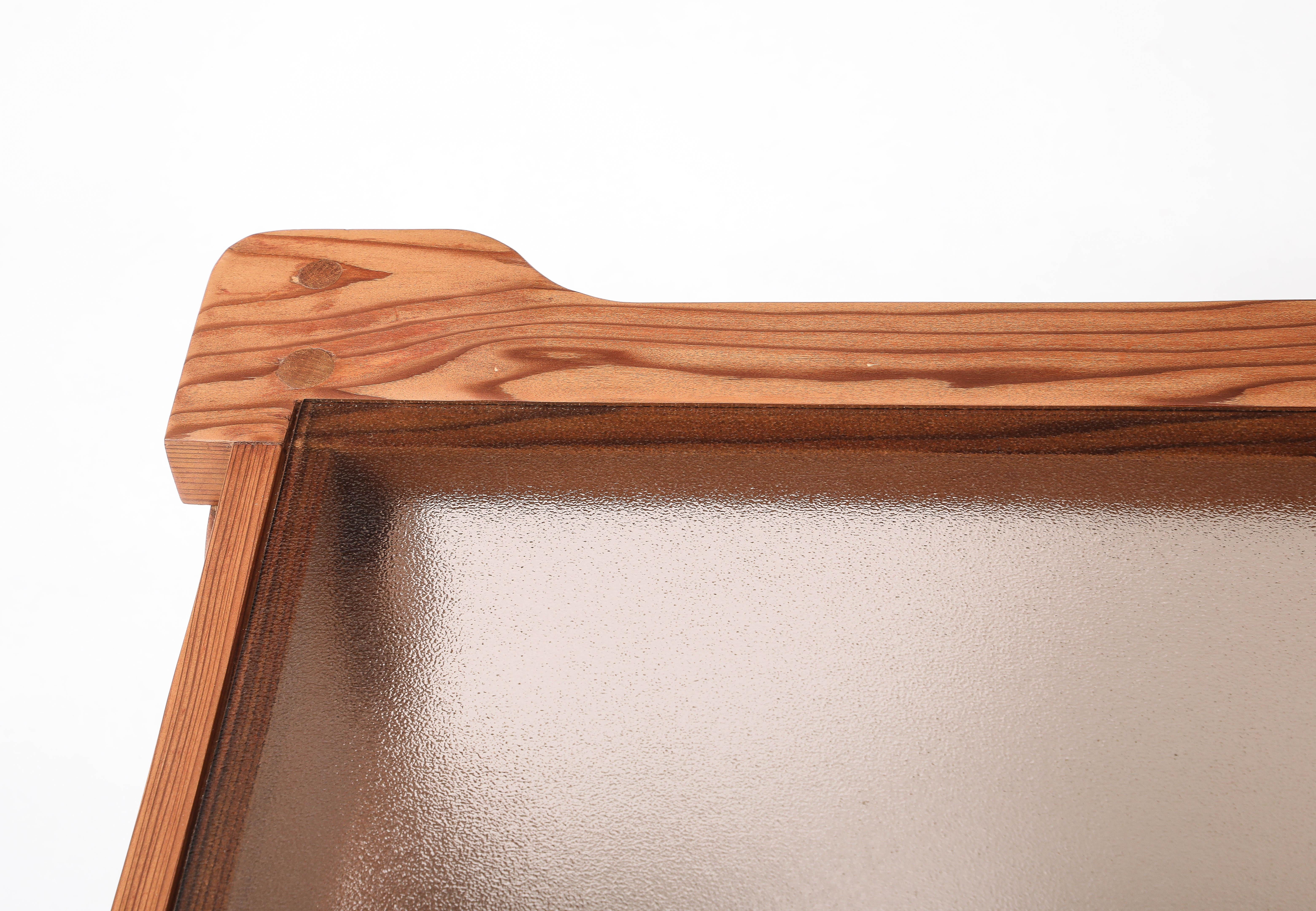 Table basse en pin de l'Oregon avec des pieds et un cadre sculptés de manière intéressante, avec un insert en verre fumé texturé.