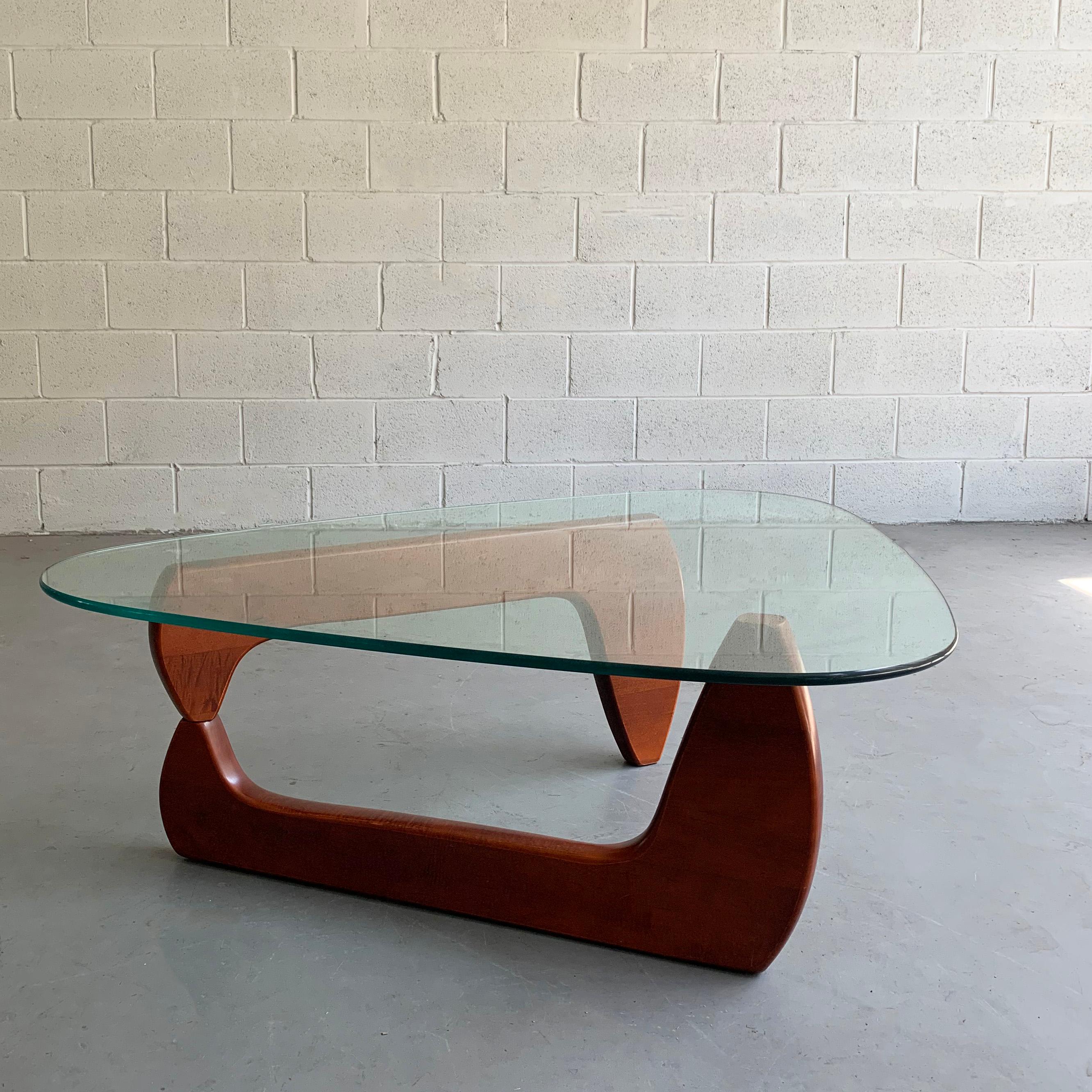 Mid-Century Modern coffee table in the Classic style of Isamu Noguchi features a pivoting, biomorphic, stained maple base with triangular glass top.