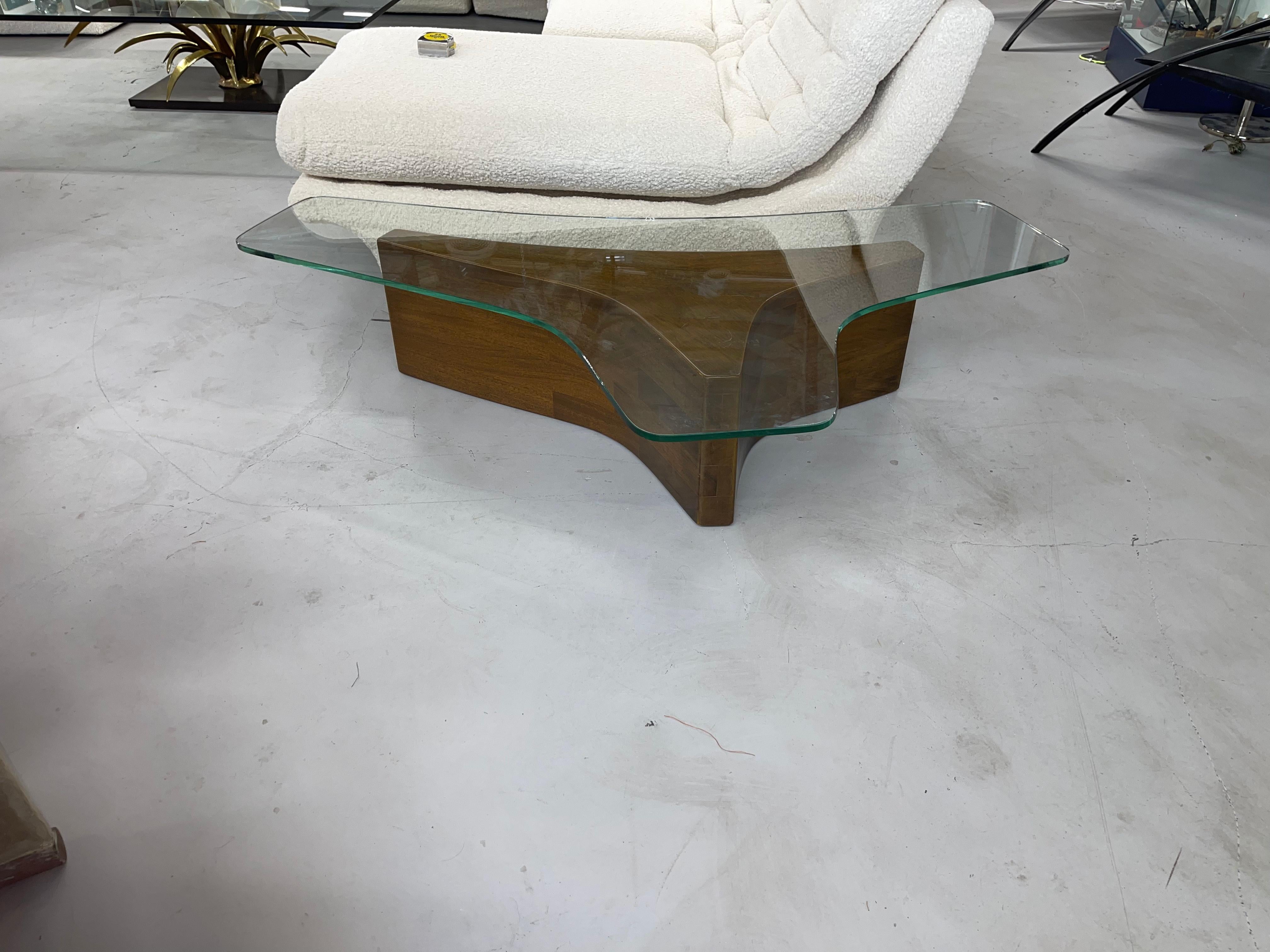 Wonderfully shaped coffee table after a design of Vladimir Kagan. Great period mid century table. Beautifully shaped glass on a sculptural base. Glass has some surface scratches, and the base has a few imperfections.
