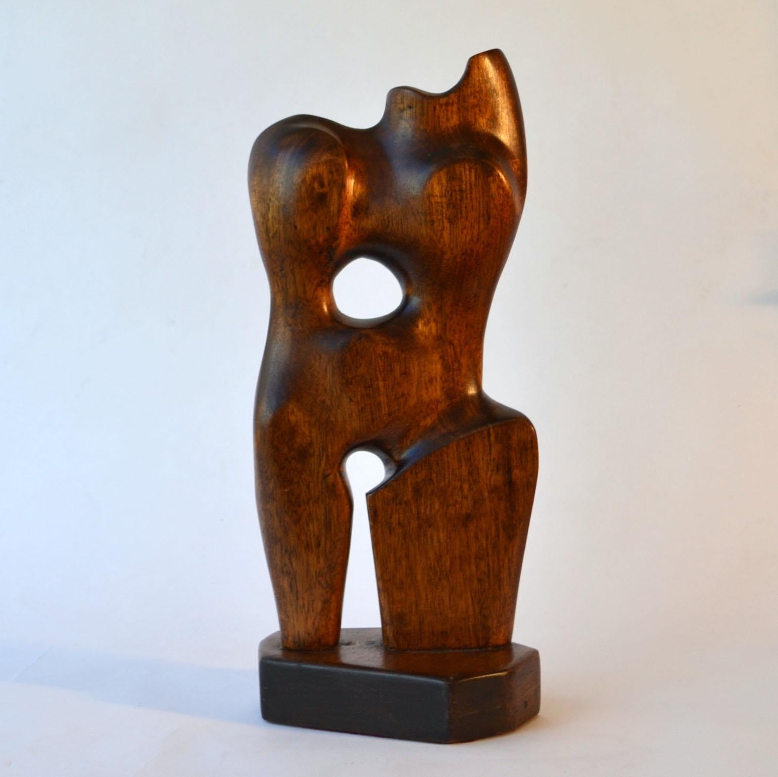 The hand carved mahogany female torso sculpture shows the influence of Jean Arp and Henry Moore. Reducing the human form to a simple abstract form, ejecting the rigid structure of straight lines and embracing biomorphic form through chance and