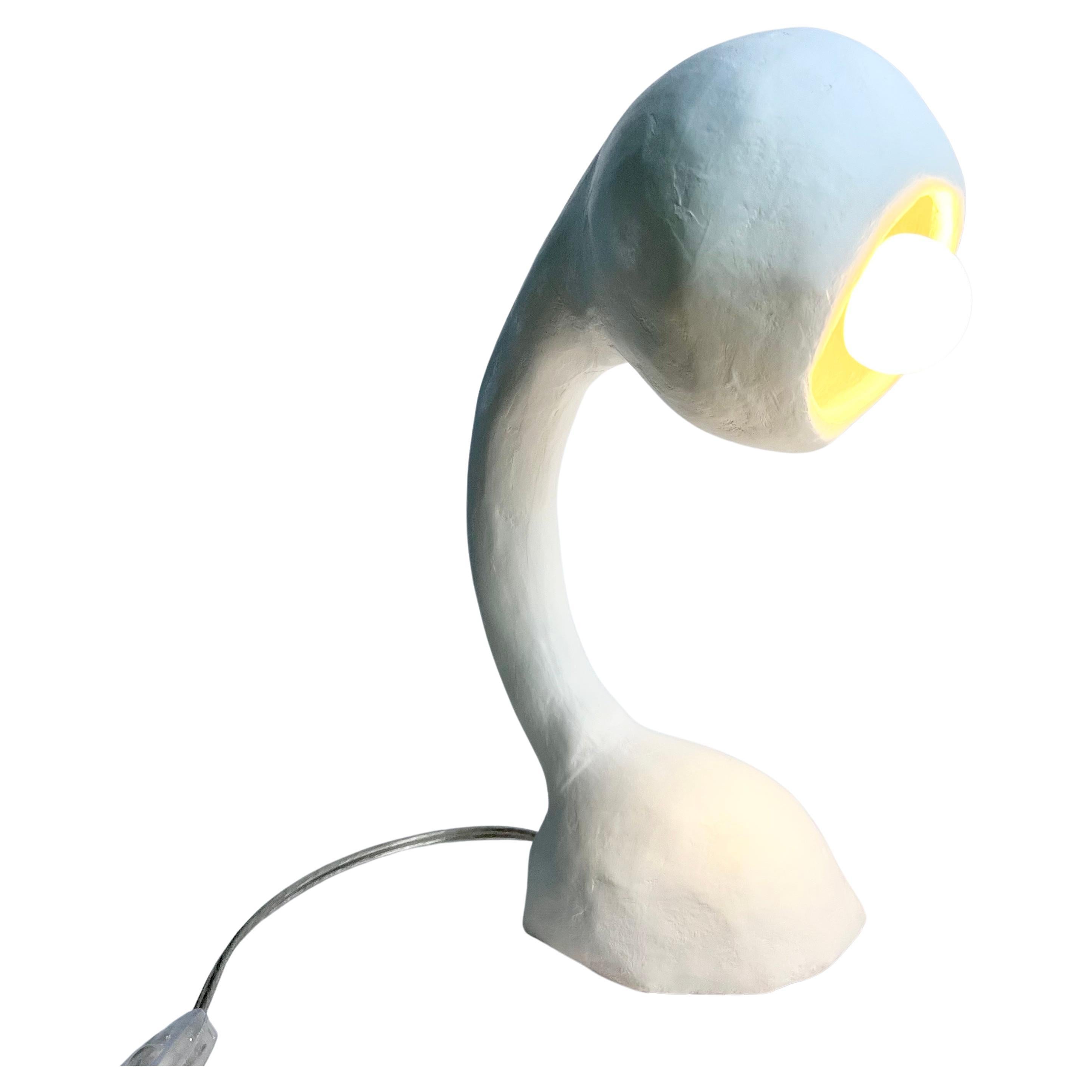 Description:
White table lamp. Ceramic socket. Included round LED G16 40W candelabra bulb in a soft white. 8’-0” clear cord. This particular Biomorphic light fixture is upright, functioning as a task or reading lamp with a slight tilt to the