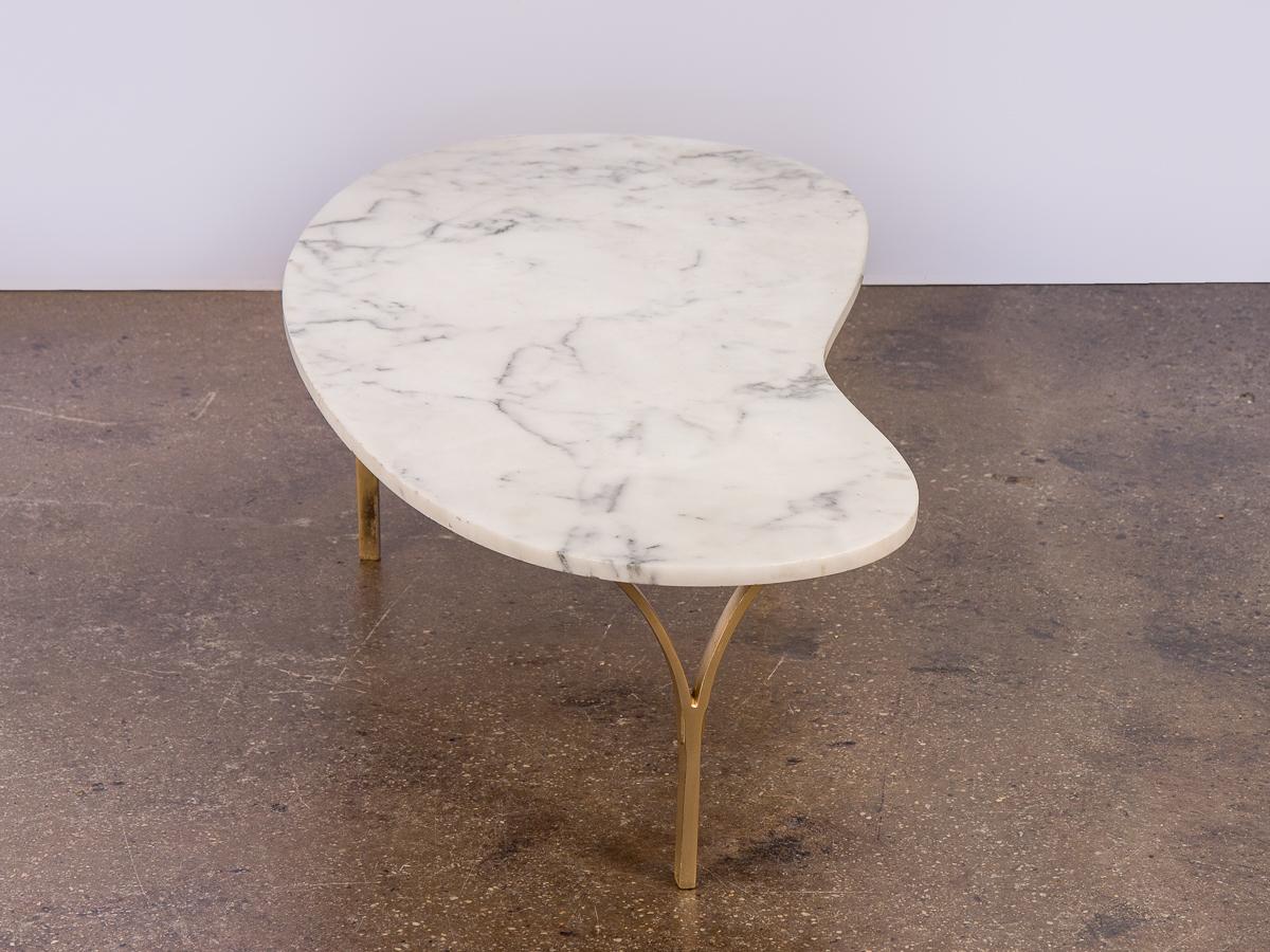 Organic, biomorphic marble coffee table. Minimal design features three curved brass legs, and a gorgeous, expansive white marble top that is very clean. In excellent vintage condition.
