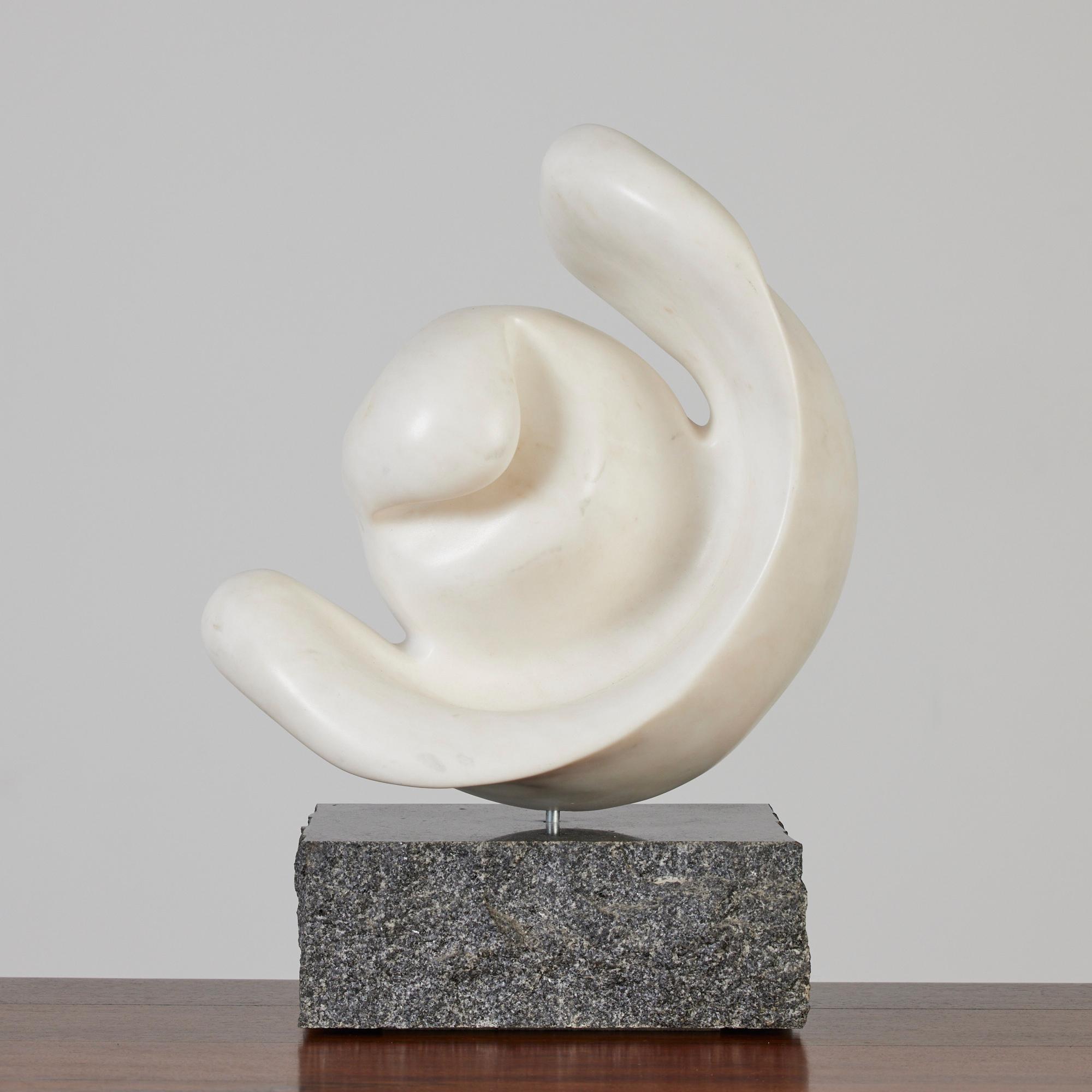 This curvaceous biomorphic marble sculpture catches your eye from all angles! The sculpture is carved from honed white marble with brown speckling throughout. The heavy granite base features a polished top and sides with a raw natural stone finish.