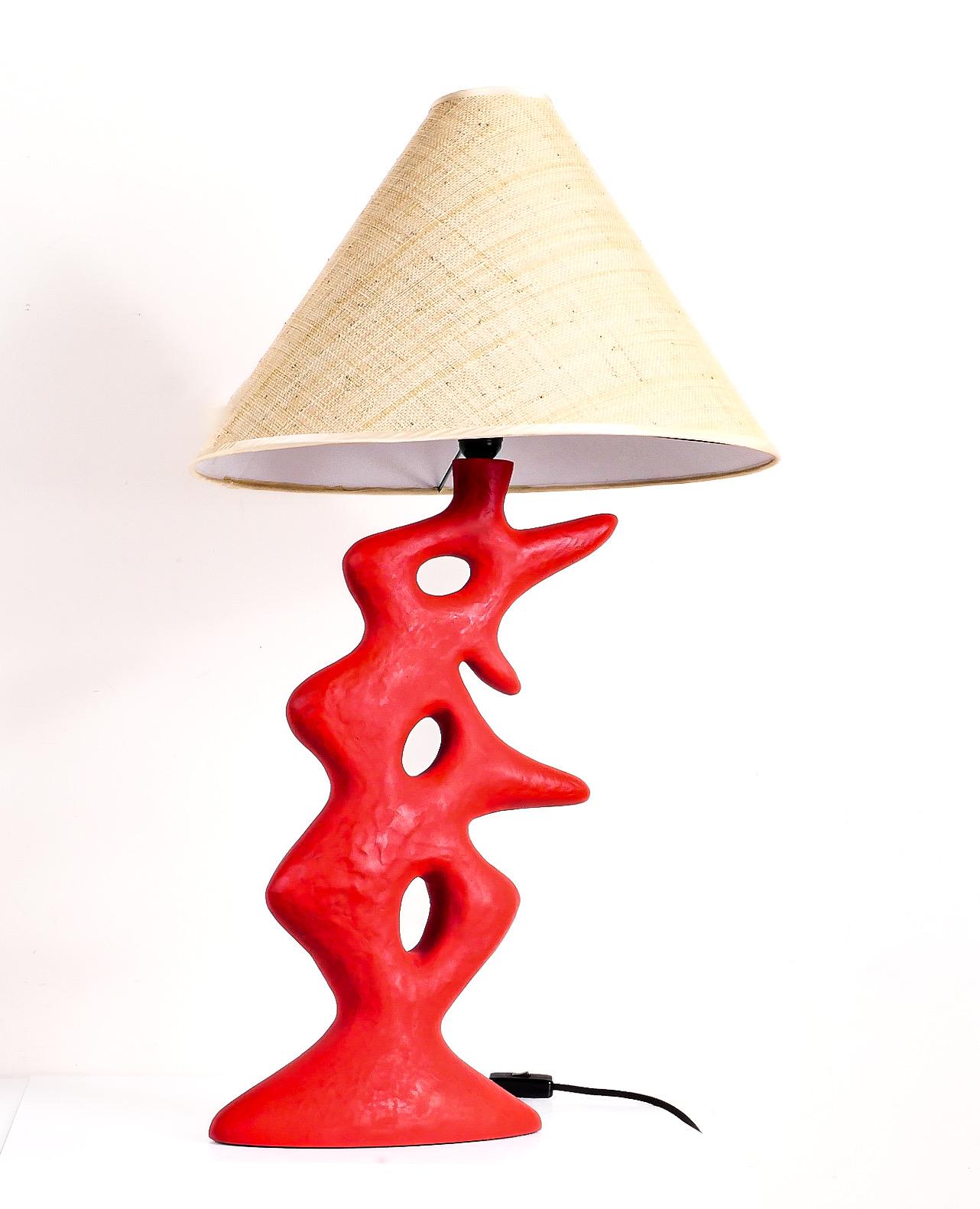 “Leon” table lamp by Elizabeth Garouste. Part of her exhibition spring 2024 at Ralph Pucci. Constructed of poppy red tinted plaster glass- an unusual material and process which yields a sculpture similar feeling to stone. Raffia shade is original to
