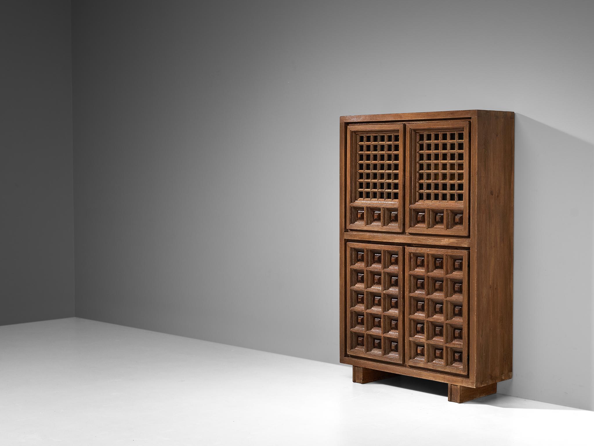Biosca, highboard, stained pine, Spain, 1960s 

Outstanding Spanish cabinet that is executed by Biosca in an architectural way. The door panels feature a relief surface of graphic carved squares. This is very typical for Brutalist style, while the