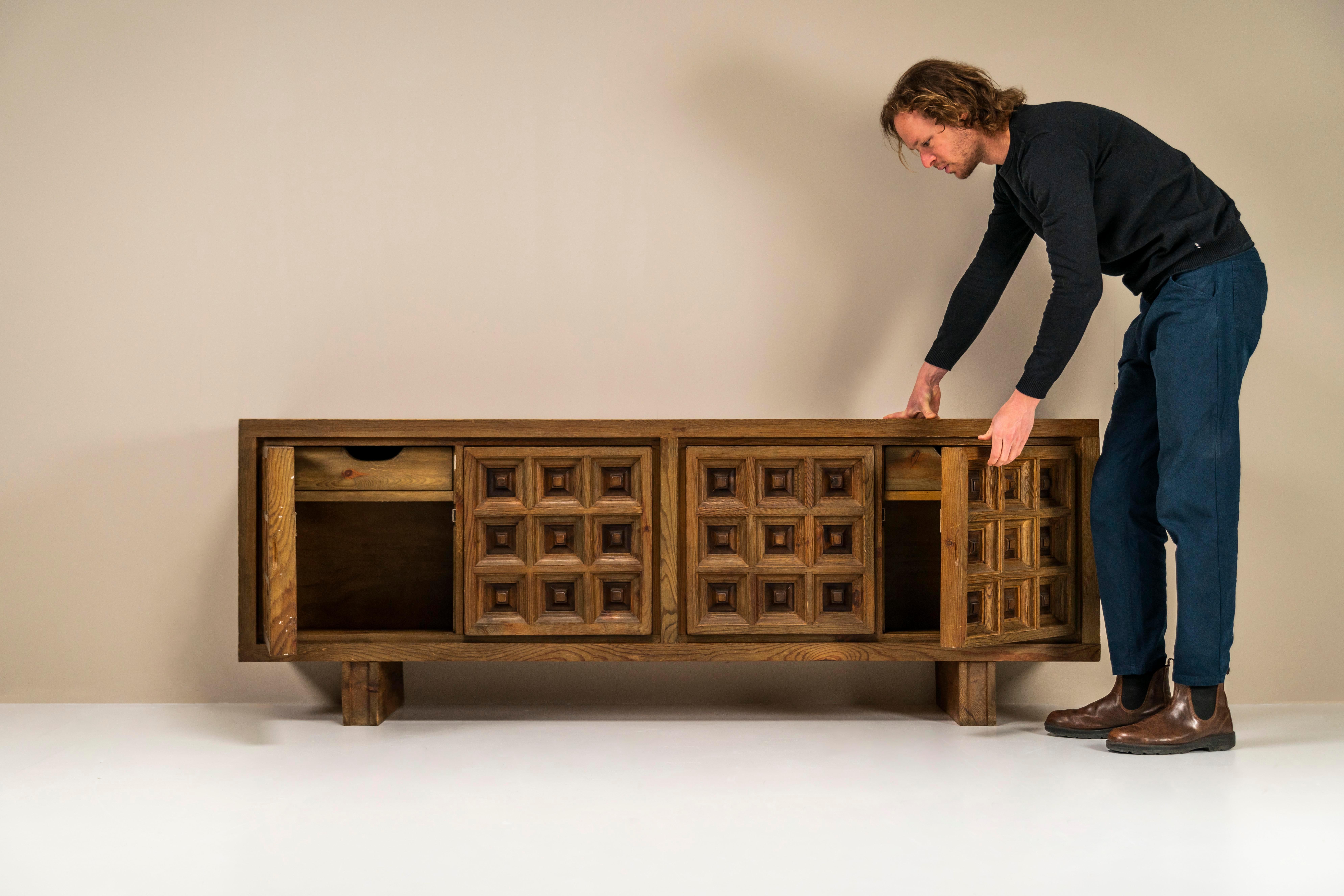 Biosca sideboard in stained pine. This sideboard from the hand of the Spanish manufacturer Biosca is an absolute paragon of the brutalism style applied in furniture. Not much is known about this illustrious manufacturer and the available examples