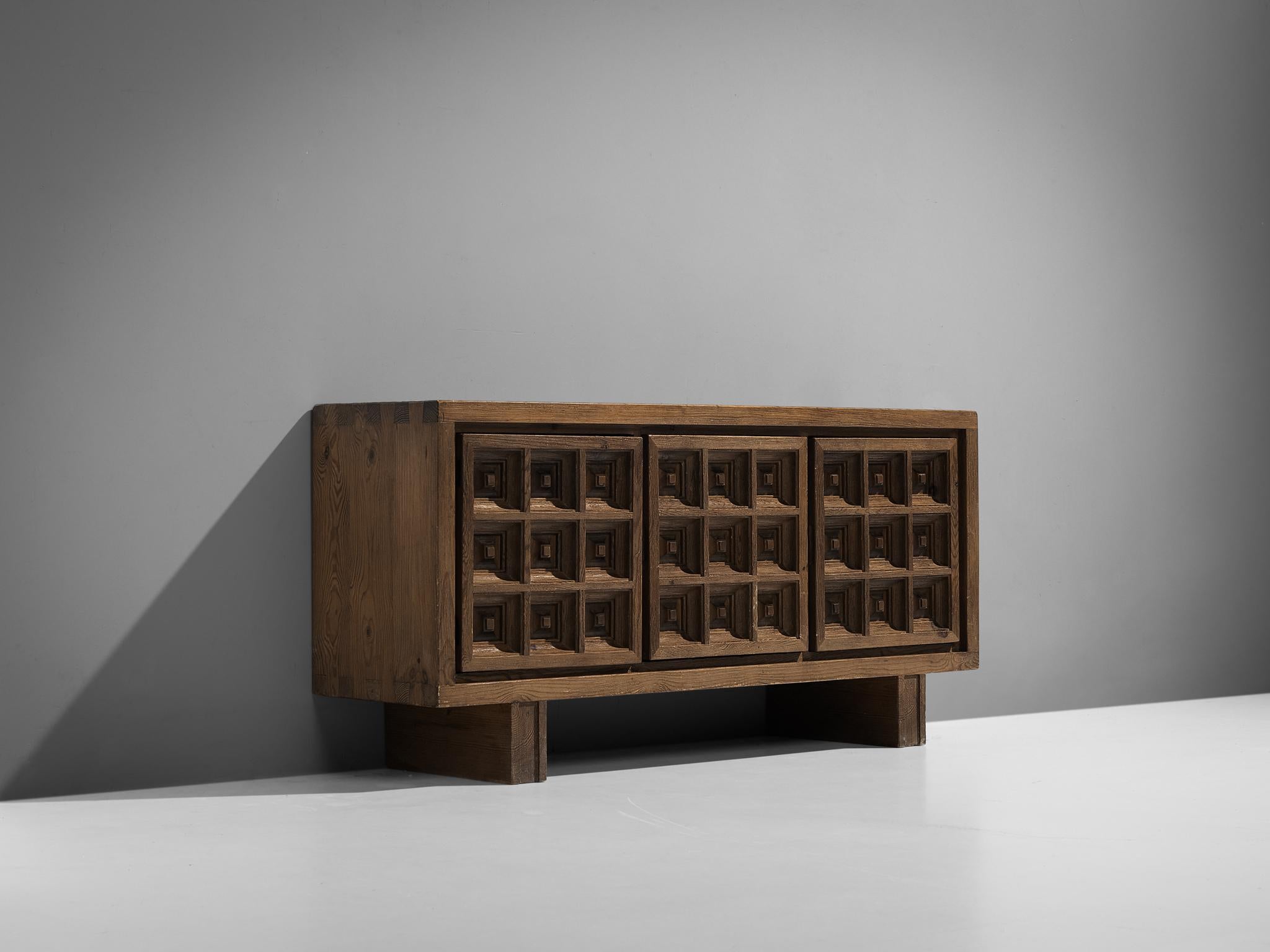 Biosca, sideboard, stained pine, Spain, 1960s.

Outstanding Spanish sideboard that is executed by Biosca in a beautiful way. The three-door credenza features doors with a graphic carved pattern. This is very typical for Brutalist style, while the