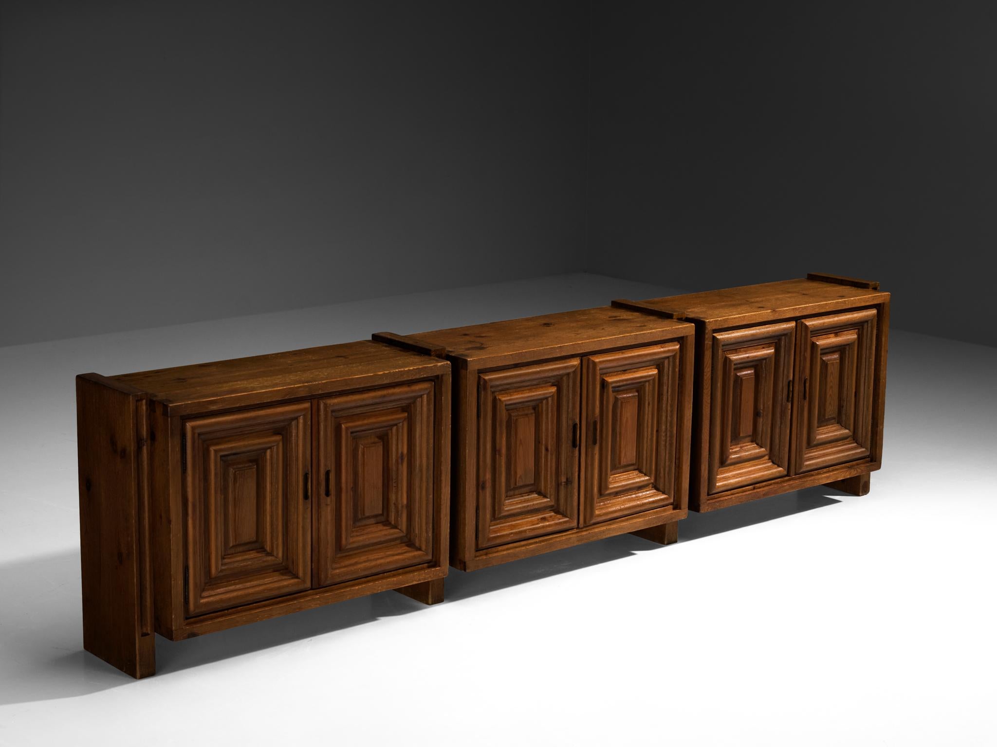 Biosca, sideboard, stained pine, Spain, 1960s.

This exceptional Spanish sideboard, masterfully crafted by Biosca, is a true work of art. The door panels feature a striking relief surface with graphic carved rectangles and rounded contours,