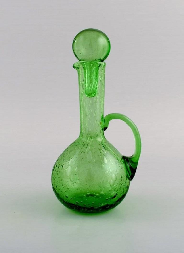 Biot, France. Two decanters, six glasses and two small jugs in green mouth-blown art glass with inlaid bubbles. Mid-20th century.
The carafe measures: 19.5 x 10.5 cm.
The glass measures: 7.5 x 5.8 cm.
The jug measures: 8 x 7.5.
In excellent