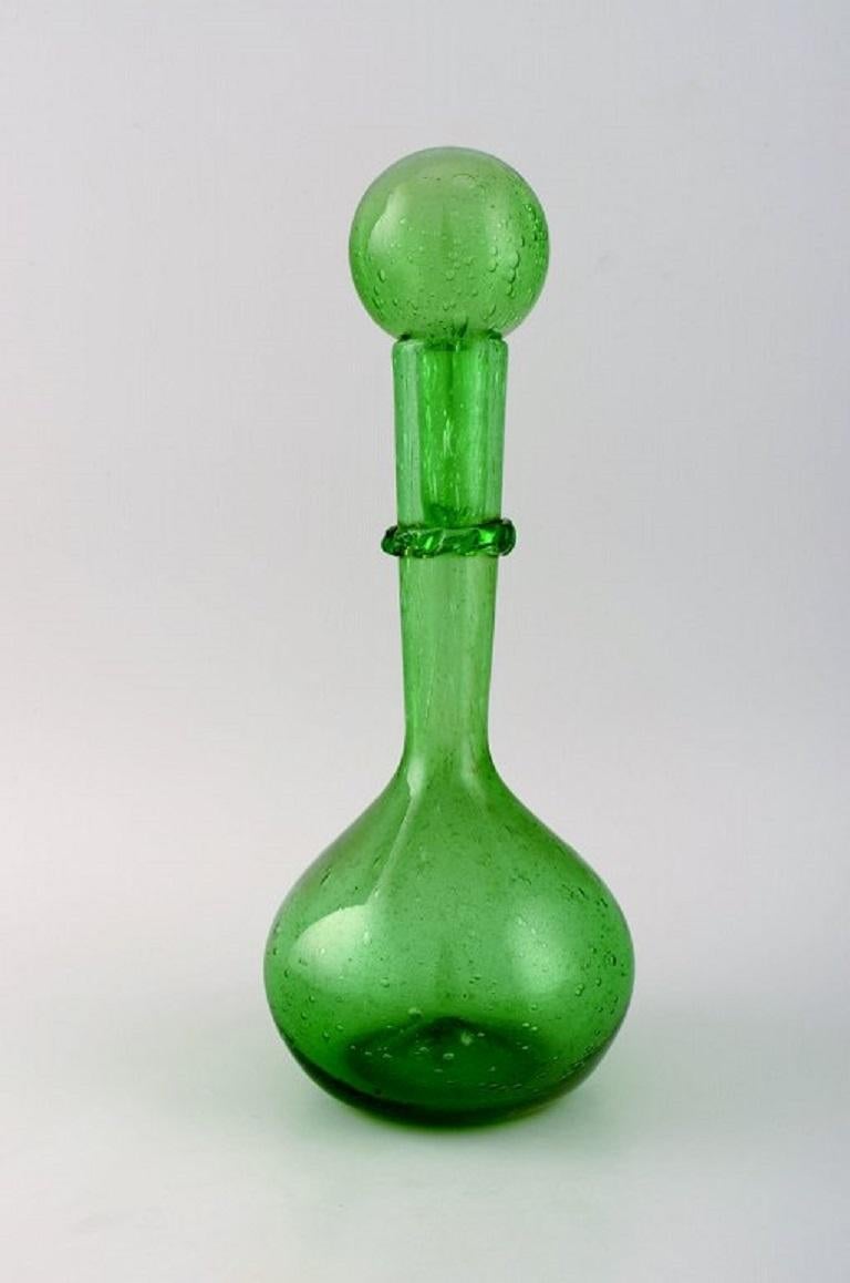 Biot, France. Two wine decanters and four glasses in green mouth-blown art glass with inlaid bubbles. 
Mid-20th century.
The decanter measures: 33 x 12.5 cm.
The glass measures: 8.5 x 7.5 cm.
In excellent condition.