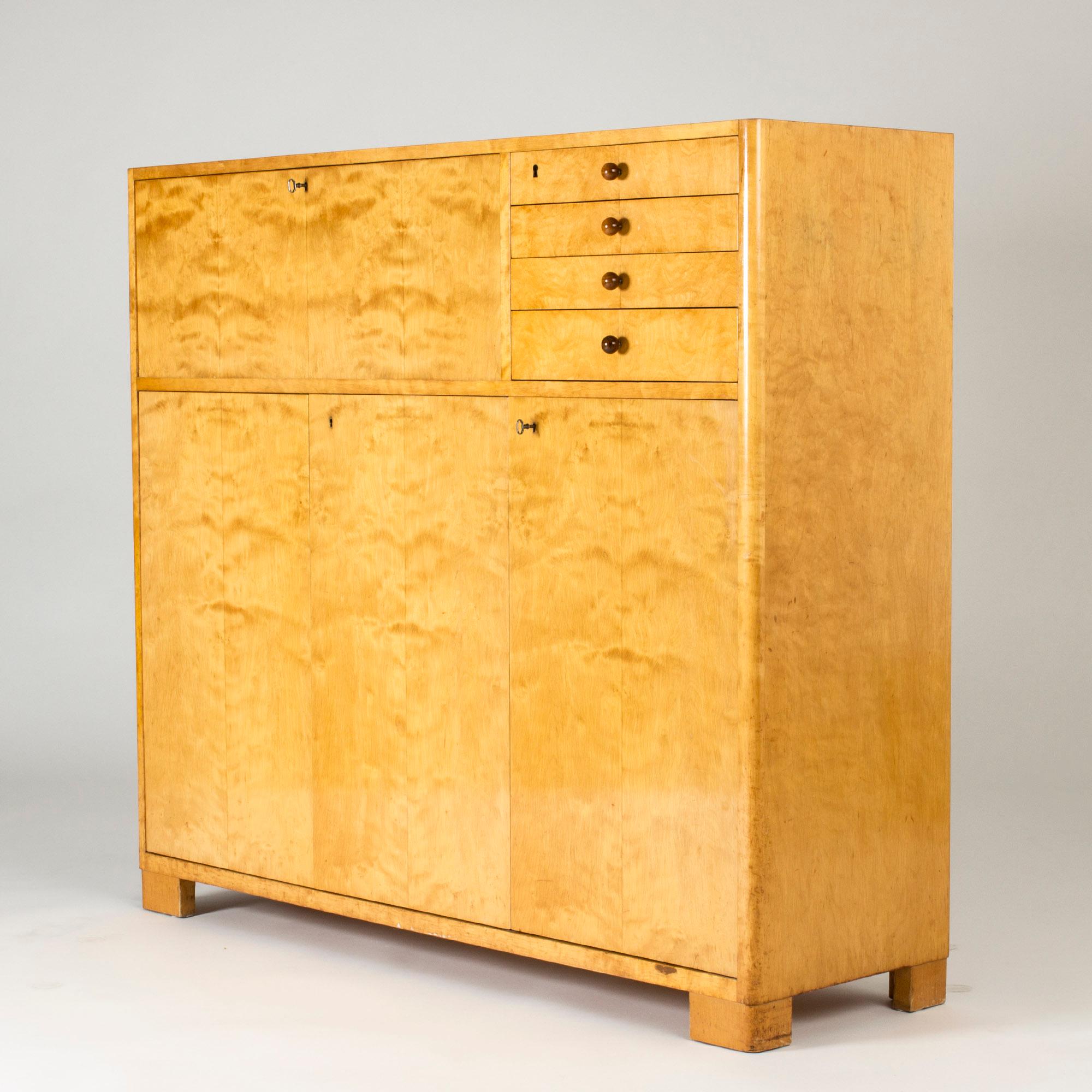 Large birch cabinet by Axel Larsson, in a functionalist design with a clean look. Appealing rounded corners and chunky feet. Nice darker wood ball-shaped handles on the drawers.